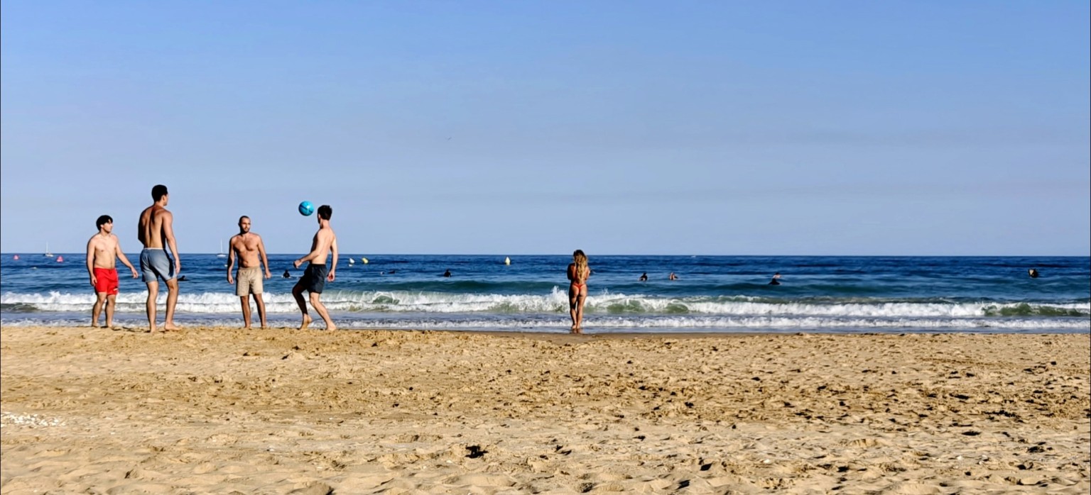 Menschen beim Ballsport an der Meia Praia